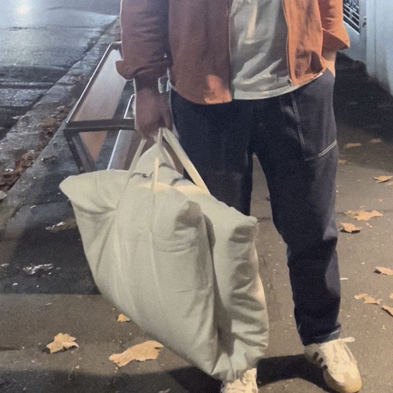 A man on a night street holding a Litual bag