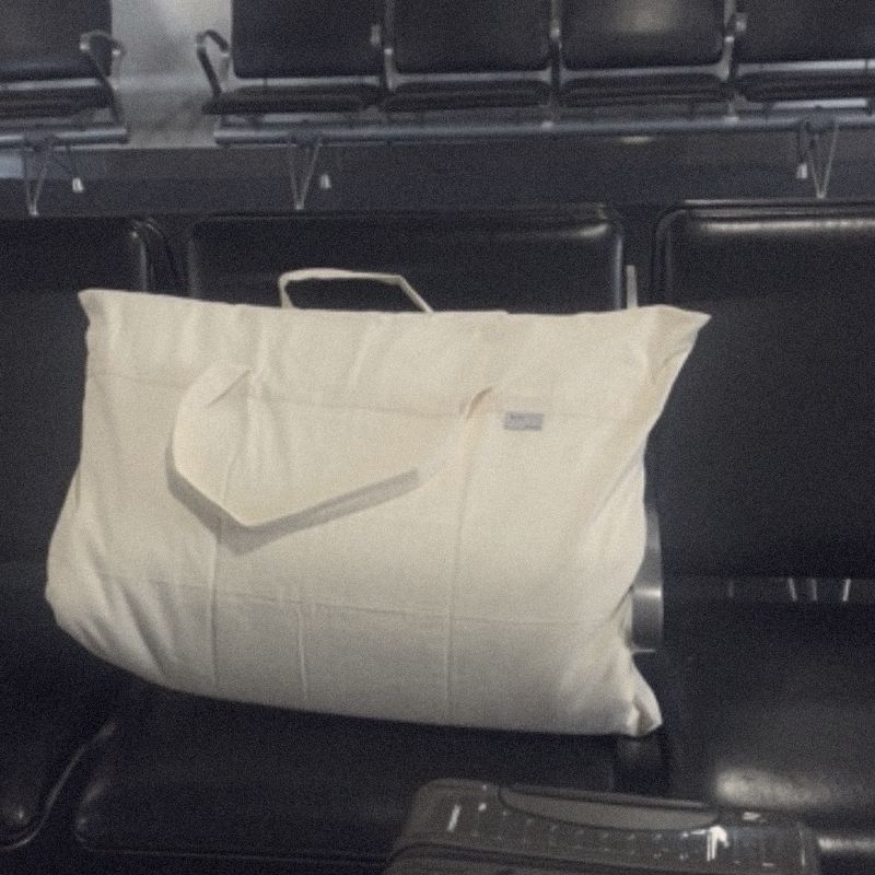 A Litual bag on a row of airport seats beside a suitcase