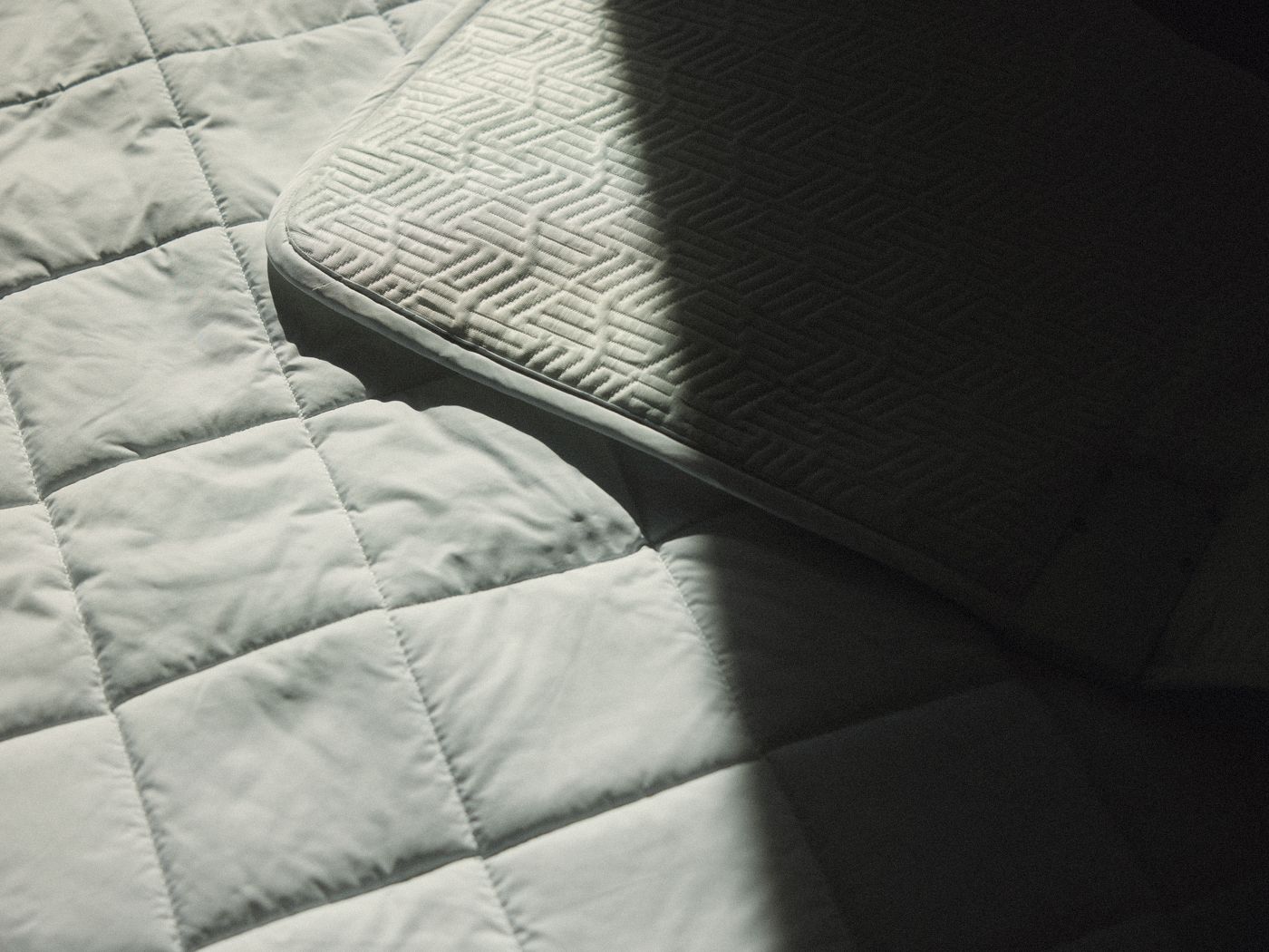 Litual's two faces in a shaft of afternoon light — the quilted cloud side below, a corner of the woven airy side folded over it
